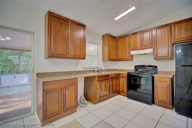 kitchen with black appliances, lofted ceiling, light tile patterned floors, and sink