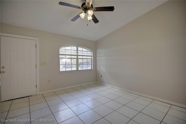 empty room featuring ceiling fan, light tile patterned flooring, and vaulted ceiling