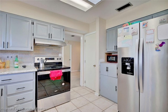 kitchen featuring backsplash, light tile patterned floors, and appliances with stainless steel finishes