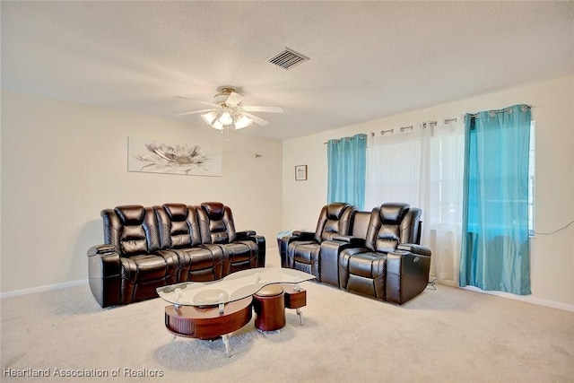 carpeted home theater featuring a textured ceiling and ceiling fan