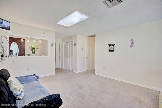 carpeted living room with a skylight and a textured ceiling