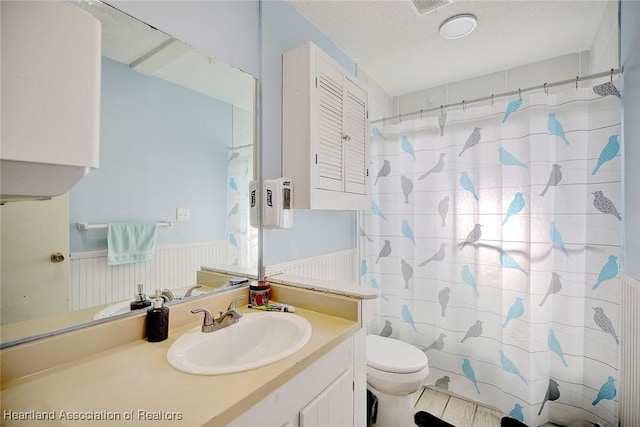 bathroom with vanity, a shower with shower curtain, a textured ceiling, and toilet