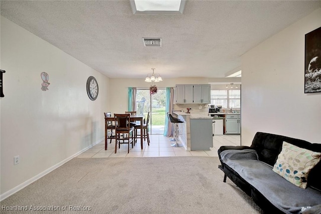 interior space with a notable chandelier, light colored carpet, and a textured ceiling