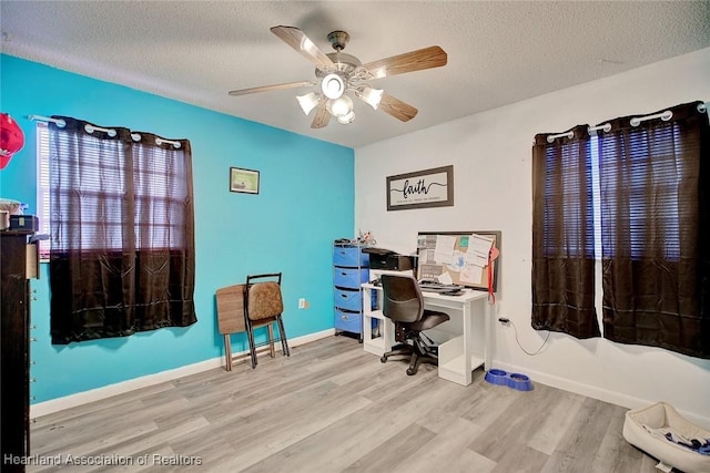 office space with ceiling fan, light hardwood / wood-style floors, and a textured ceiling