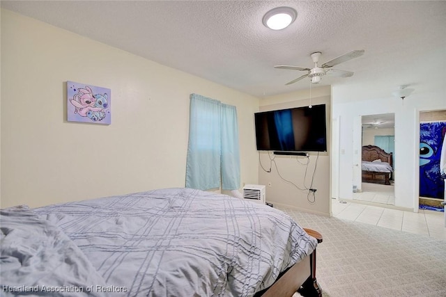 bedroom with ceiling fan, light colored carpet, and a textured ceiling