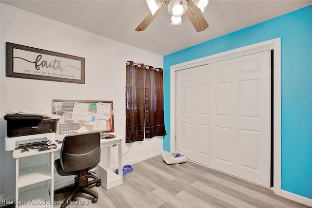 office space with ceiling fan, a textured ceiling, and light wood-type flooring