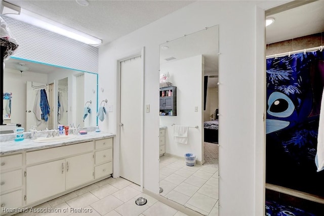 bathroom with vanity, a textured ceiling, and tile patterned floors