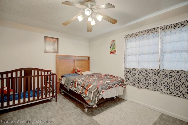 bedroom with ceiling fan and a textured ceiling