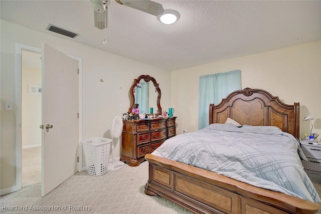 carpeted bedroom featuring ceiling fan and a textured ceiling