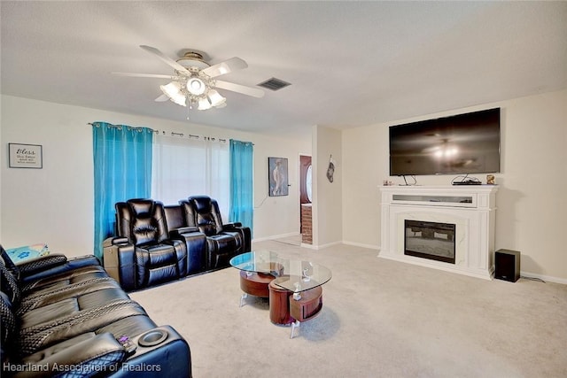 living room featuring carpet flooring, ceiling fan, a fireplace, and a textured ceiling