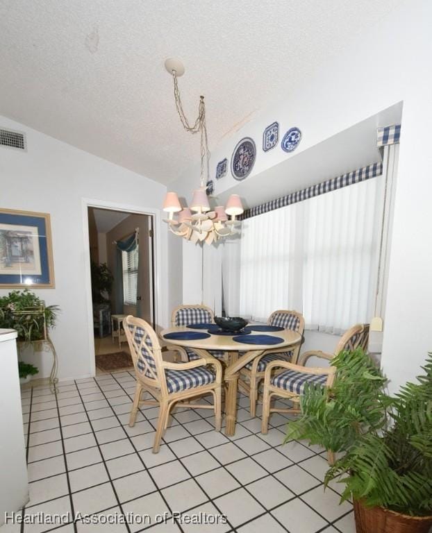 4310 Duffer Loop, Sebring, FL 33872 - dining room with lofted ceiling, an inviting chandelier, visible vents, light tile patterned flooring, and a textured ceiling