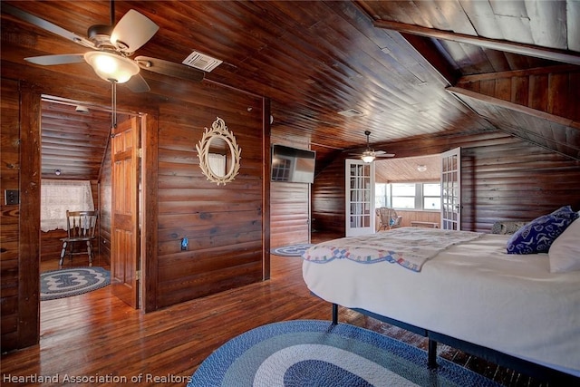 bedroom featuring ceiling fan, wooden ceiling, wood walls, wood-type flooring, and lofted ceiling