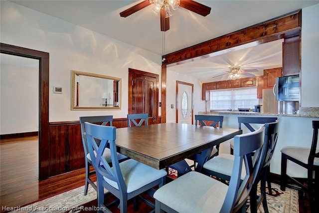 dining room with beam ceiling, light wood-type flooring, and ceiling fan