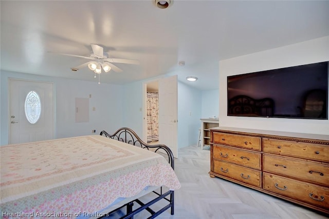 bedroom with ceiling fan, ensuite bathroom, and light parquet floors