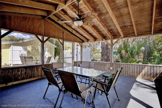 sunroom / solarium with vaulted ceiling with beams, ceiling fan, and wood ceiling