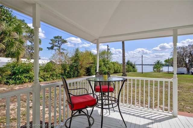 sunroom / solarium featuring a water view, a wealth of natural light, and lofted ceiling