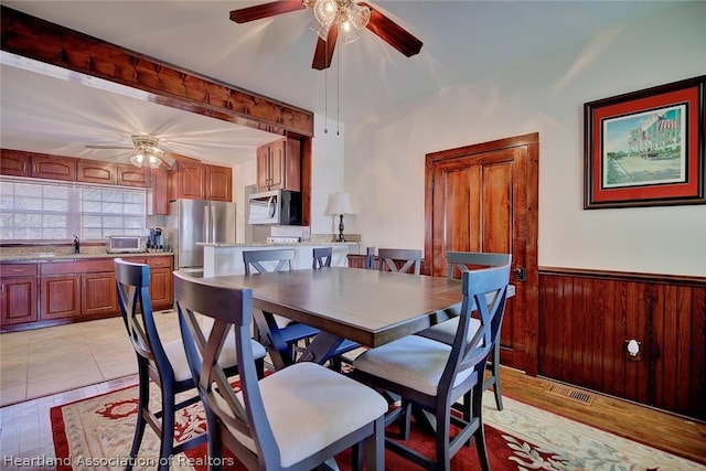 dining area featuring wooden walls and sink