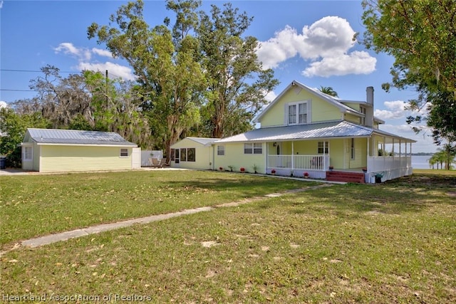 view of front of property featuring a porch, an outdoor structure, and a front yard