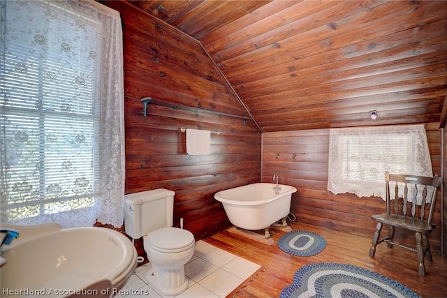 bathroom with hardwood / wood-style floors, a bathing tub, vaulted ceiling, rustic walls, and wood ceiling