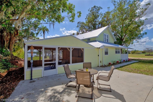 rear view of property with a sunroom and a patio