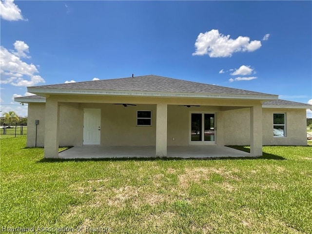 rear view of property with a yard, ceiling fan, and a patio area