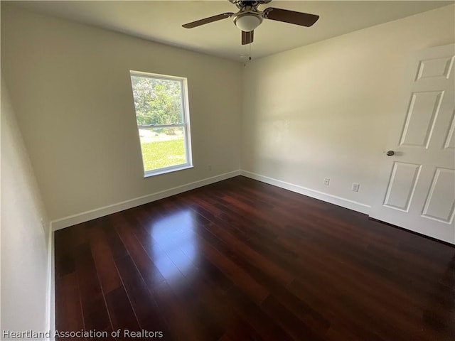 empty room with ceiling fan and dark wood-type flooring