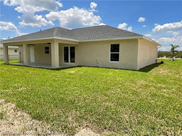 back of property with a patio area and a yard