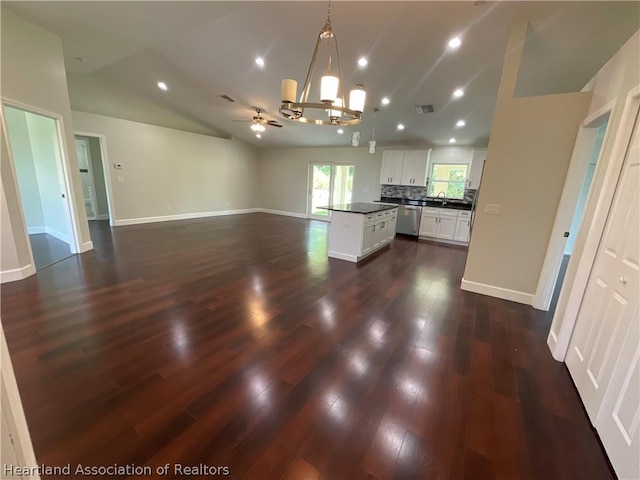 kitchen with dishwasher, a kitchen island, lofted ceiling, decorative light fixtures, and white cabinets