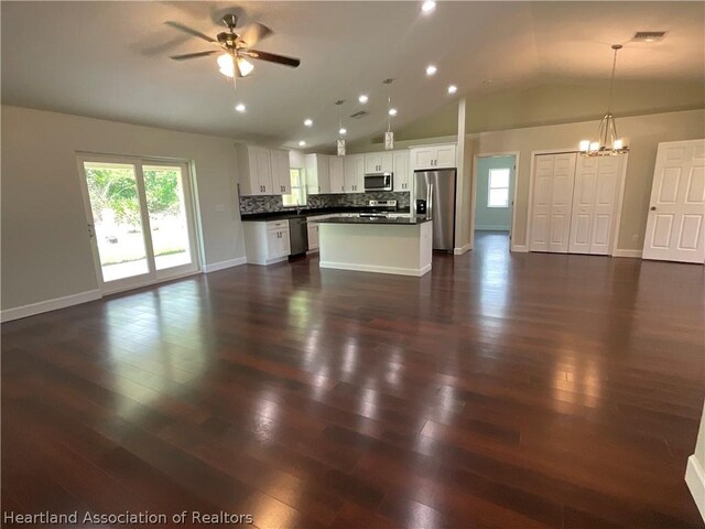 unfurnished living room with ceiling fan with notable chandelier, dark hardwood / wood-style floors, and lofted ceiling