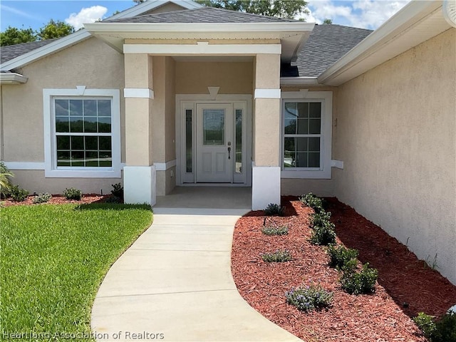 property entrance with a lawn