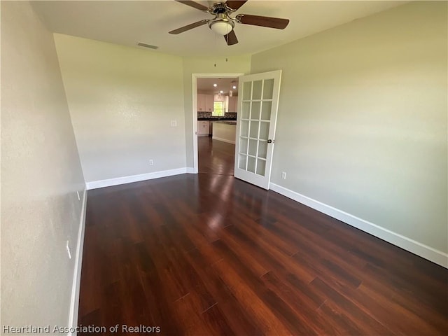 empty room with ceiling fan and dark wood-type flooring