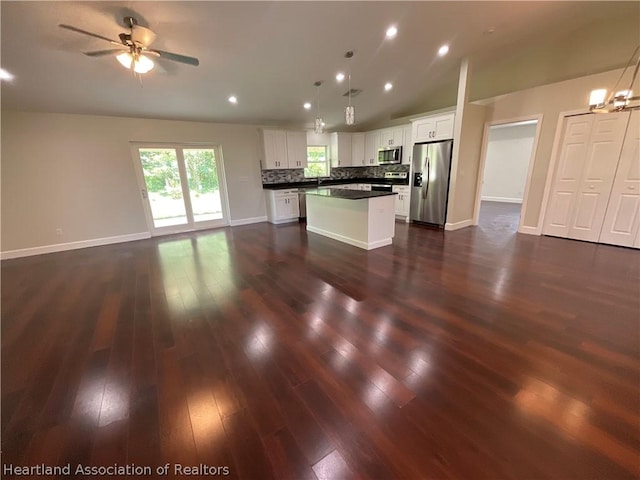 kitchen featuring appliances with stainless steel finishes, a center island, white cabinetry, and pendant lighting