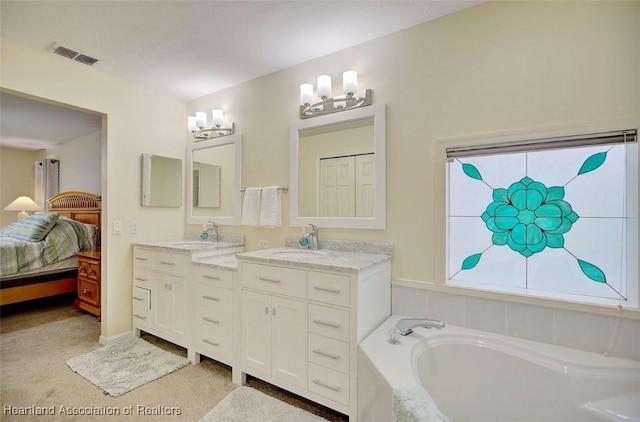 bathroom with vanity and a relaxing tiled tub