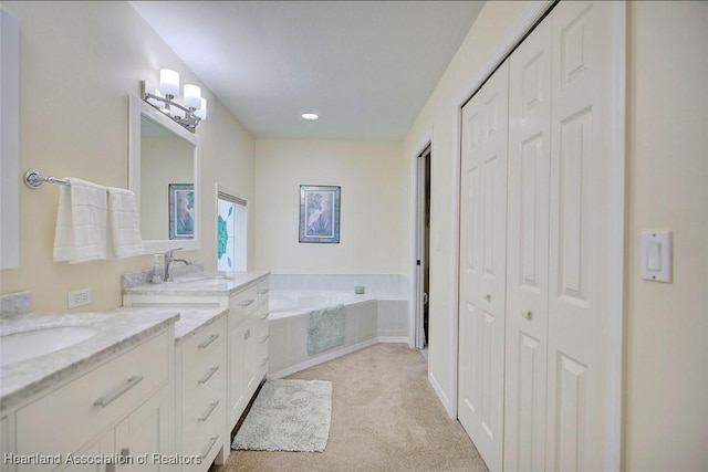 bathroom with vanity and tiled bath