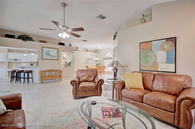 tiled living room with ceiling fan with notable chandelier