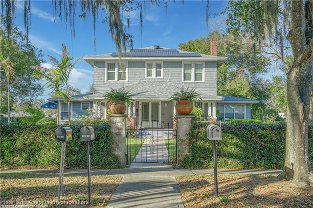 883 S Eucalyptus St, Sebring, FL 33870 - view of front facade with a gate, a chimney, roof mounted solar panels, and a fenced front yard