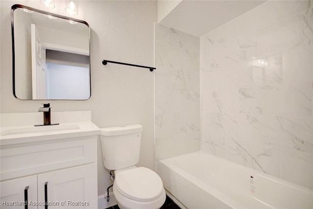 full bathroom featuring vanity, tiled shower / bath, and toilet