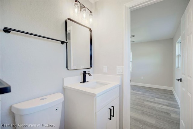 bathroom featuring vanity, hardwood / wood-style flooring, and toilet