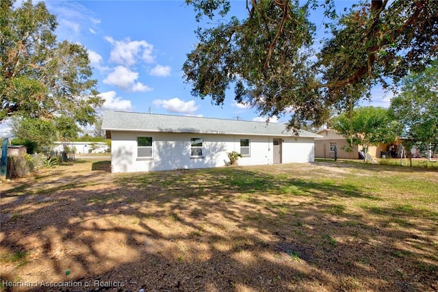 back of house featuring a lawn