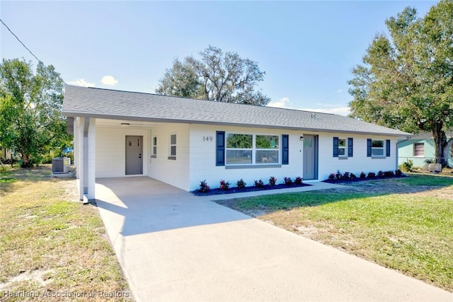 single story home featuring a carport, central air condition unit, and a front yard