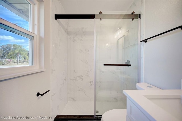 bathroom featuring vanity, toilet, and a shower with door