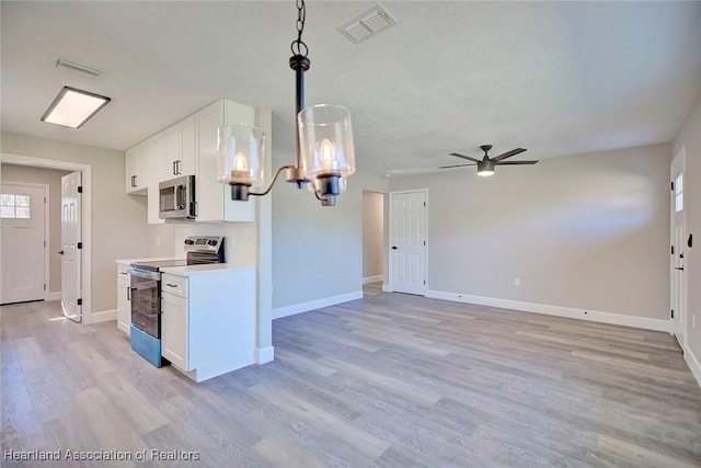 kitchen featuring white cabinetry, ceiling fan, light hardwood / wood-style flooring, pendant lighting, and appliances with stainless steel finishes