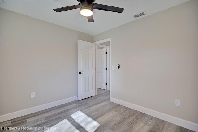 spare room with ceiling fan and light wood-type flooring