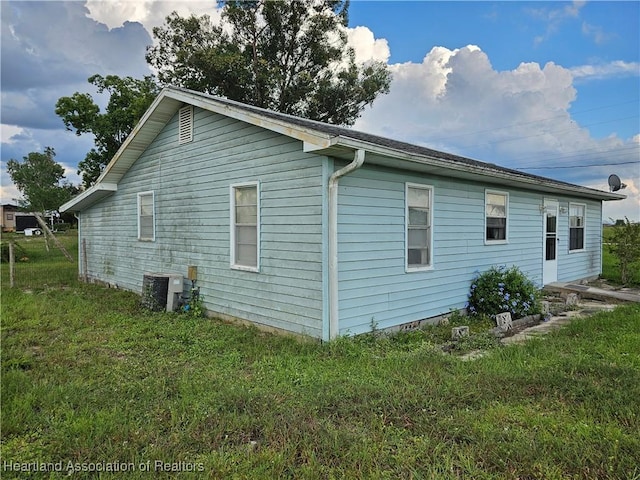 view of home's exterior featuring a lawn and cooling unit