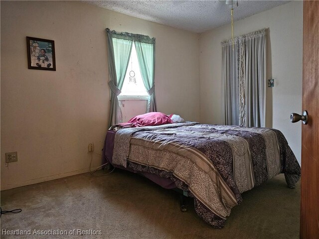 bedroom with carpet floors and a textured ceiling