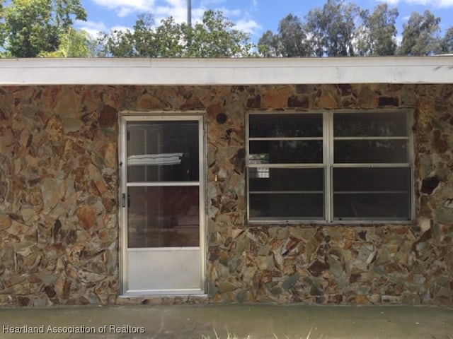entrance to property with stone siding