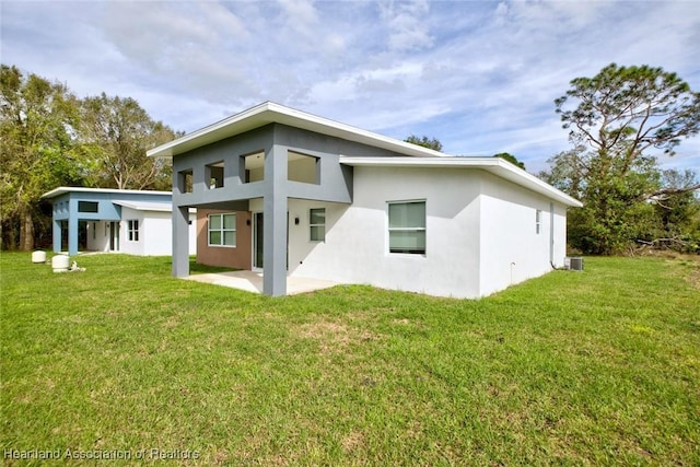 back of property featuring central air condition unit, a yard, and a patio