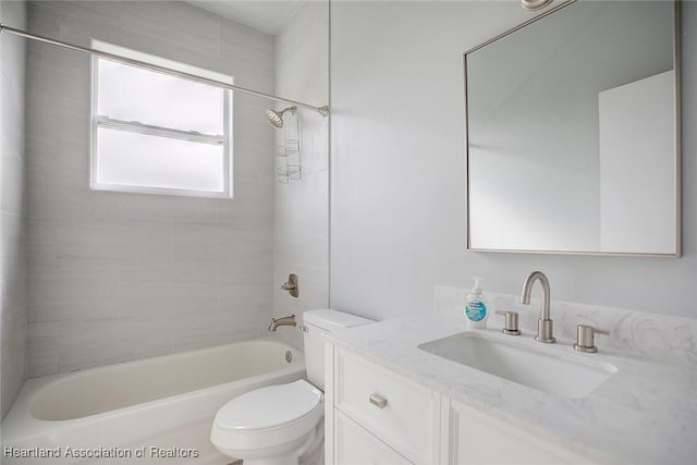 full bathroom featuring toilet, vanity, and tiled shower / bath