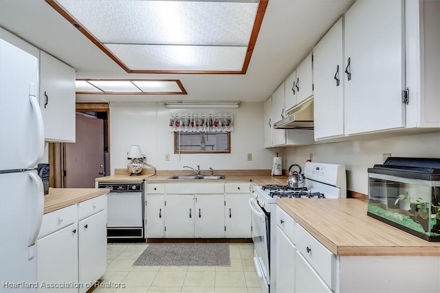 kitchen with white appliances, light tile patterned floors, sink, and white cabinets