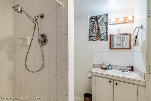 bathroom featuring a tile shower and vanity